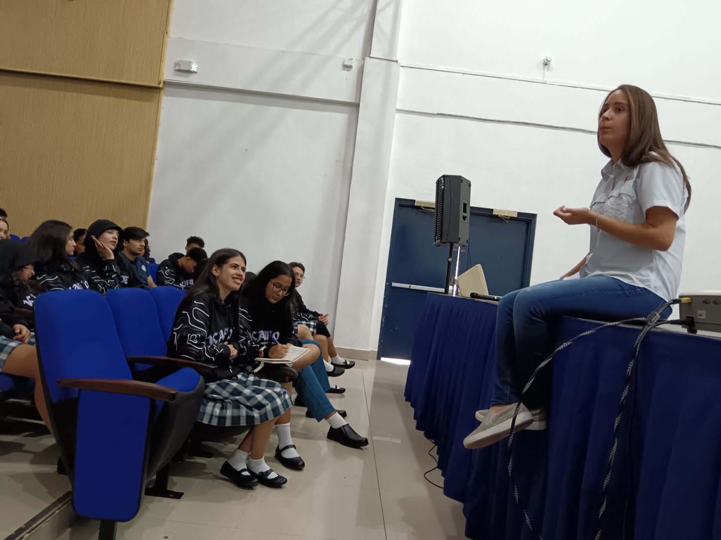 Facilitadora compartiendo con estudiantes en auditorio