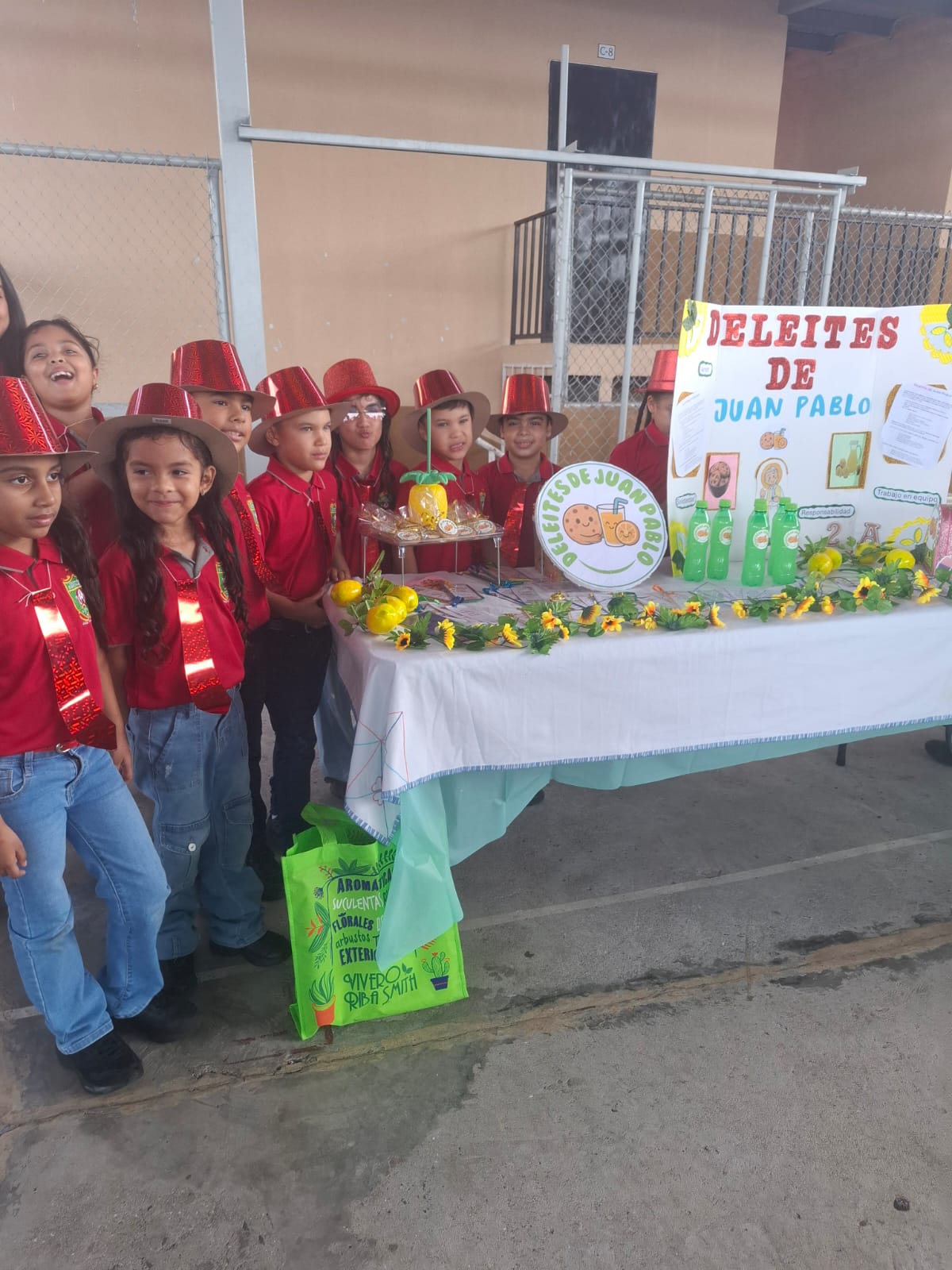 Stand Deleites de Juan Pablo con estudiantes uniformados de rojo