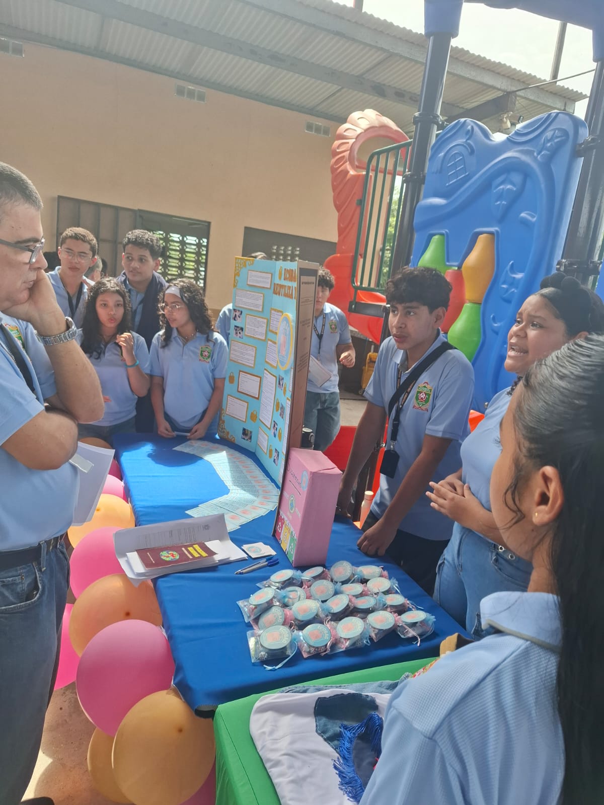 Estudiantes explicando su proyecto Ecobags a un visitante
