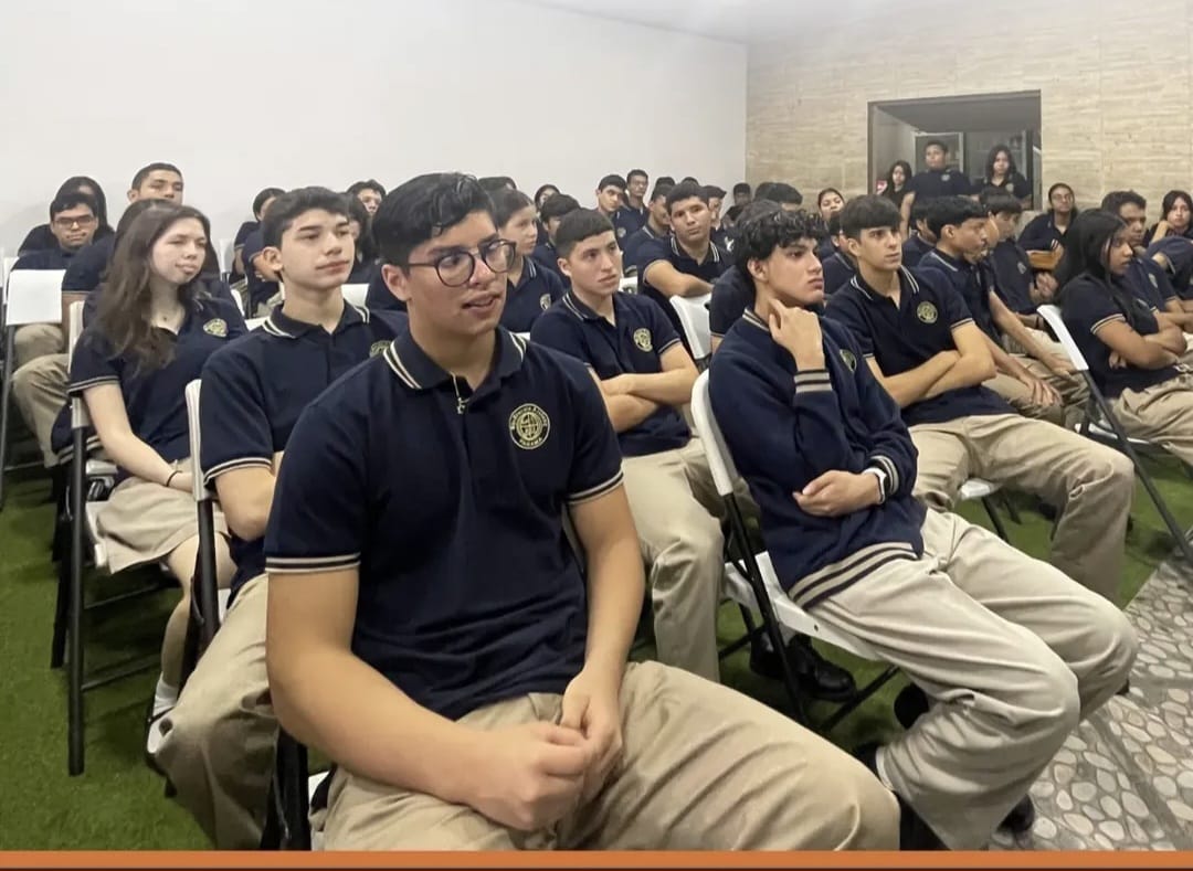 Estudiantes uniformados atentos durante la charla